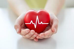close-up van de hand met cardiogram op rood hart
