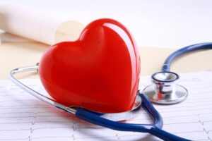 หัวใจสีแดงและหูฟังของแพทย์บนโต๊ะ