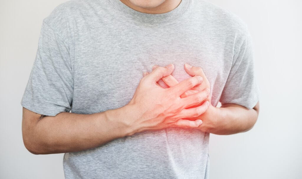 un homme touchant son cœur avec le point culminant rouge d'une crise cardiaque