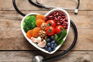 हृदय स्वस्थ आहार और स्टेथोस्कोप के लिए उत्पादों के साथ कटोरा