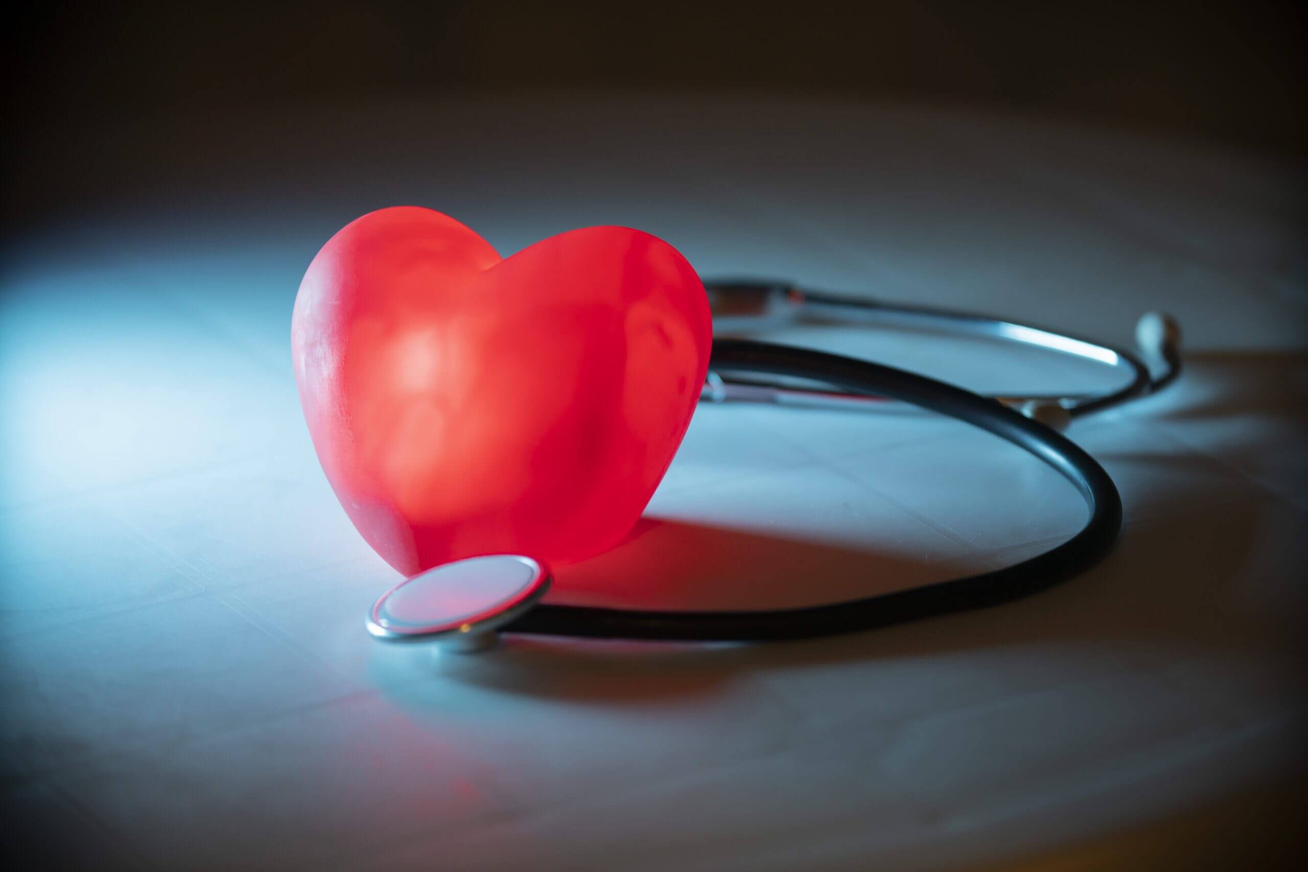Coeur rouge avec stéthoscope sur fond bleu